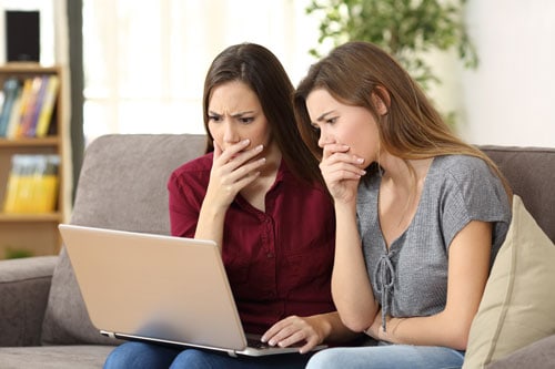 Two anxious white women watching COVID news stoires - survive and thrive COVID pandemic