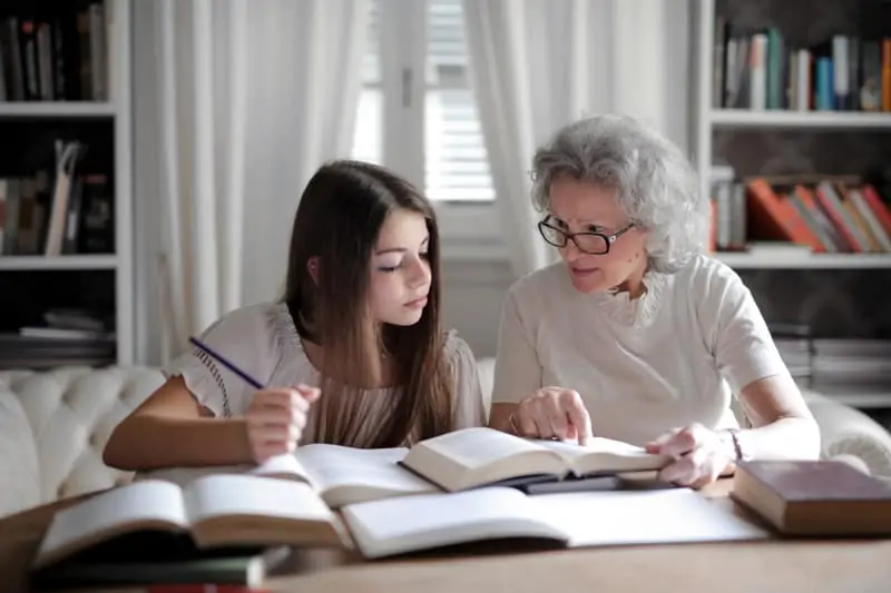 Photo by Andrea Piacquadio  
Grandmother homeschooling girl at a table. Caucasian