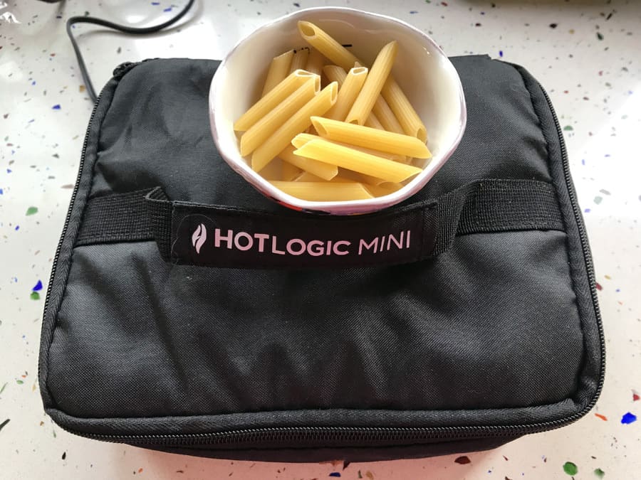Hot logic mini with bowl of dry pasta on top.