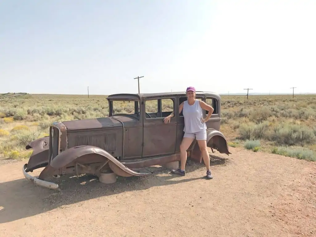Old rusted car and tourist. Route 66 Petrified Forest