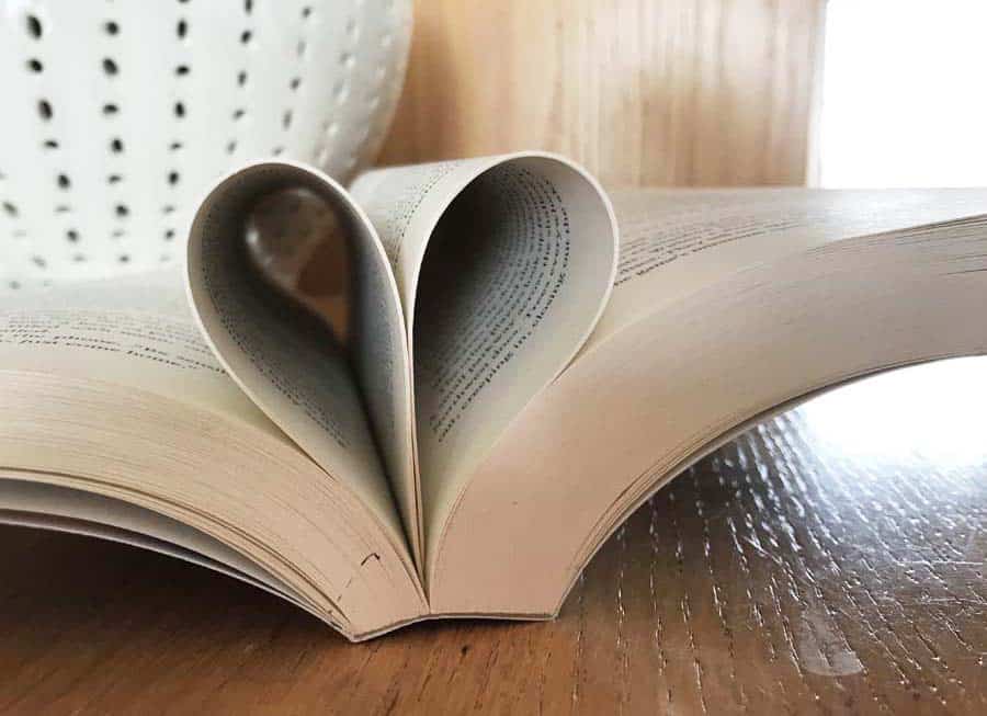 Open book with pages folded into spine to create a heart - best feel-good books