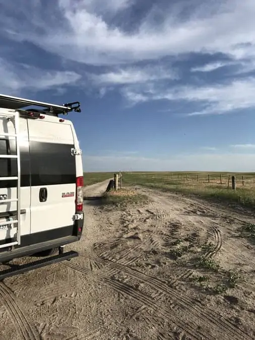 Promaster campervan on a dirt road by a farm in Nebraska. Lost. Example of a campervan road trip problem.